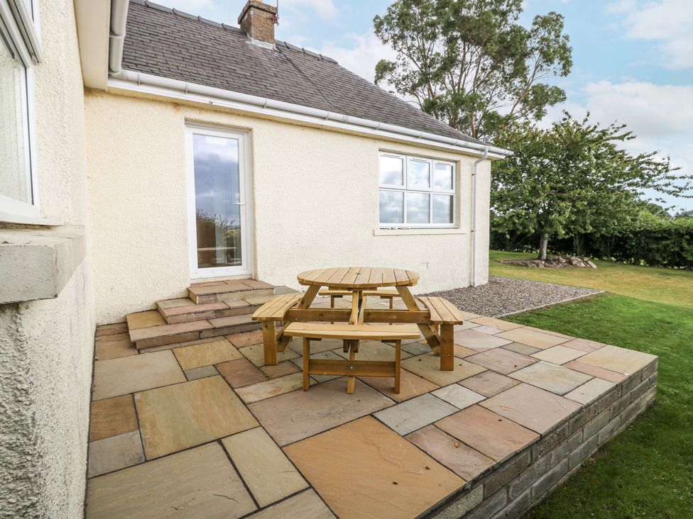 A patio area with a wooden table and benches at Top Cottage Cupar, Fife