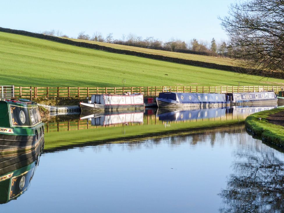 Boats on a canal reflecting greenery at Canal Side in Skipton