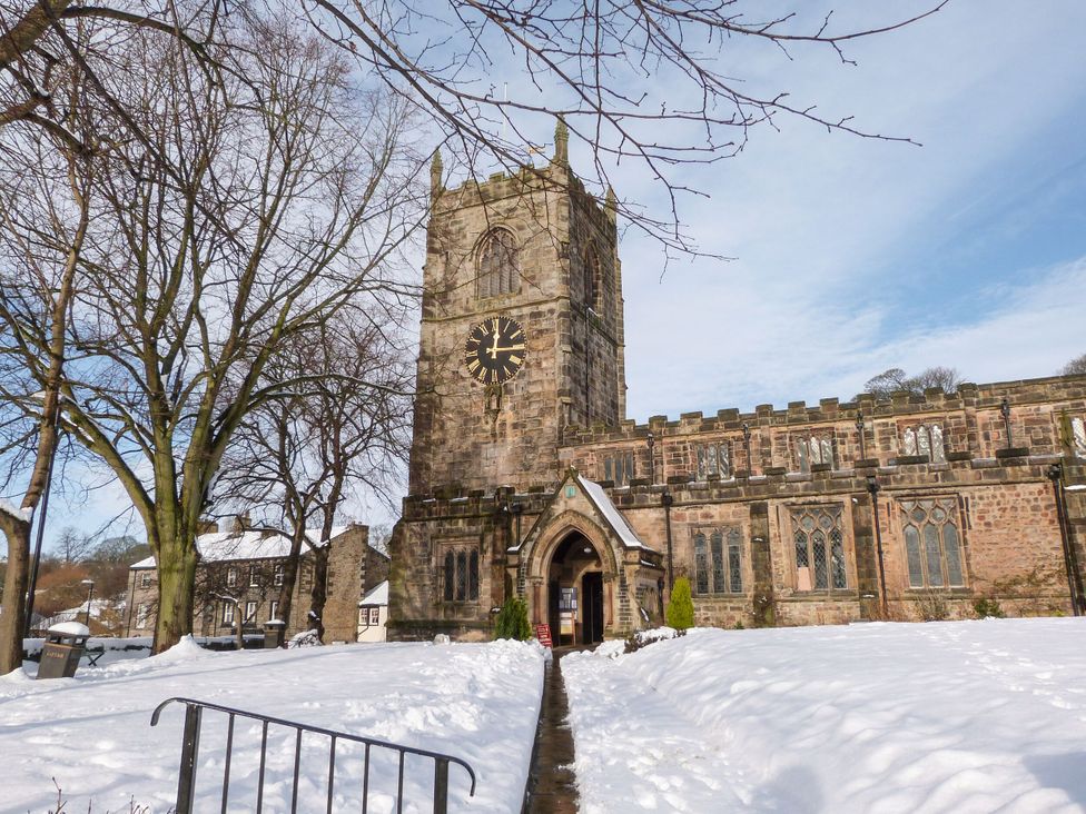 A church with a clock tower and snow-covered ground at Canal Side in Skipton
