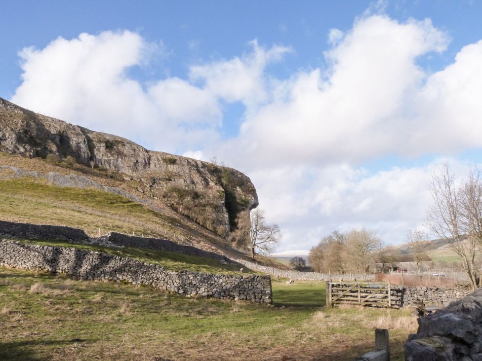 A view of a cliff and grass with a wooden fence at Canal Side Skipton