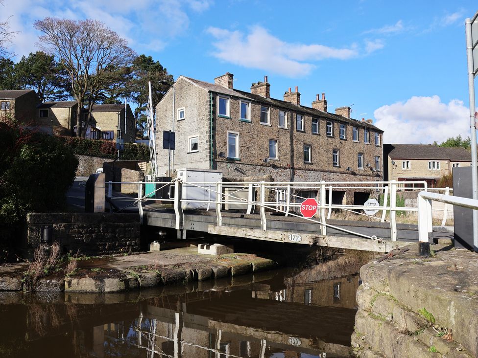 A bridge over a canal with houses in the background at Canal Side in Skipton