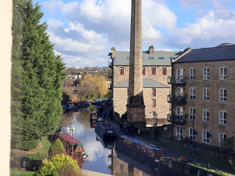 A canal with boats and buildings by the water at Canal Side in Skipton