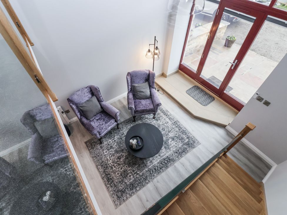 A living room with armchairs and a coffee table at Waters Edge in Skipton