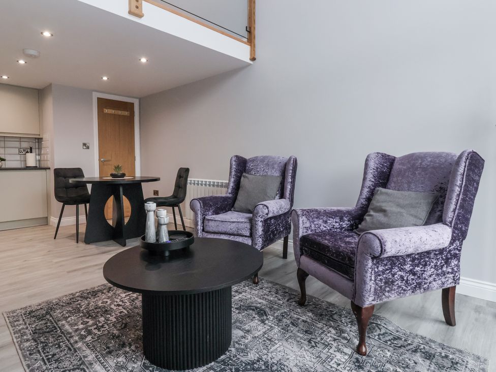 A living room with two armchairs and a coffee table at Waters Edge in Skipton