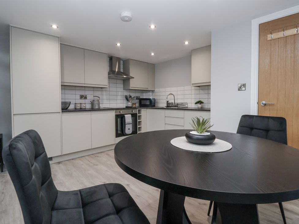 A kitchen with countertop, cabinets, and dining table at Waters Edge in Skipton