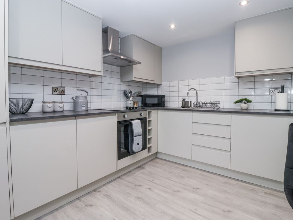 A kitchen with cabinets, sink, stove and microwave at Waters Edge in Skipton