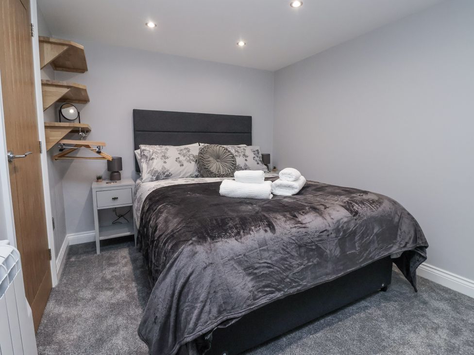 A bedroom with a bed and shelves at Waters Edge in Skipton