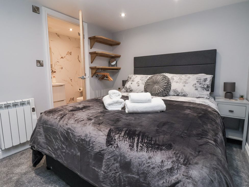 A bedroom with a bed and shelves at Waters Edge in Skipton