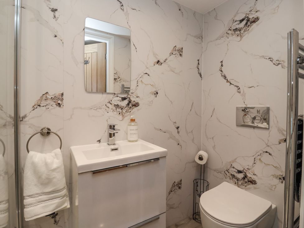 A bathroom with shower, sink, and toilet at Waters Edge in Skipton