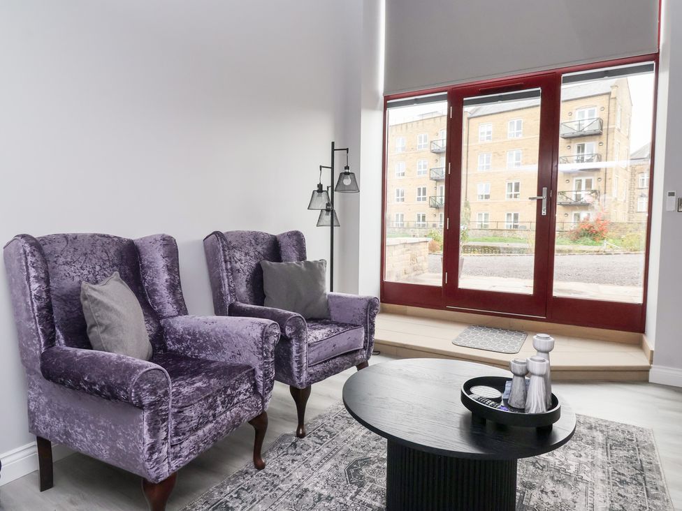 A living room with armchairs and a side table at Waters Edge in Skipton