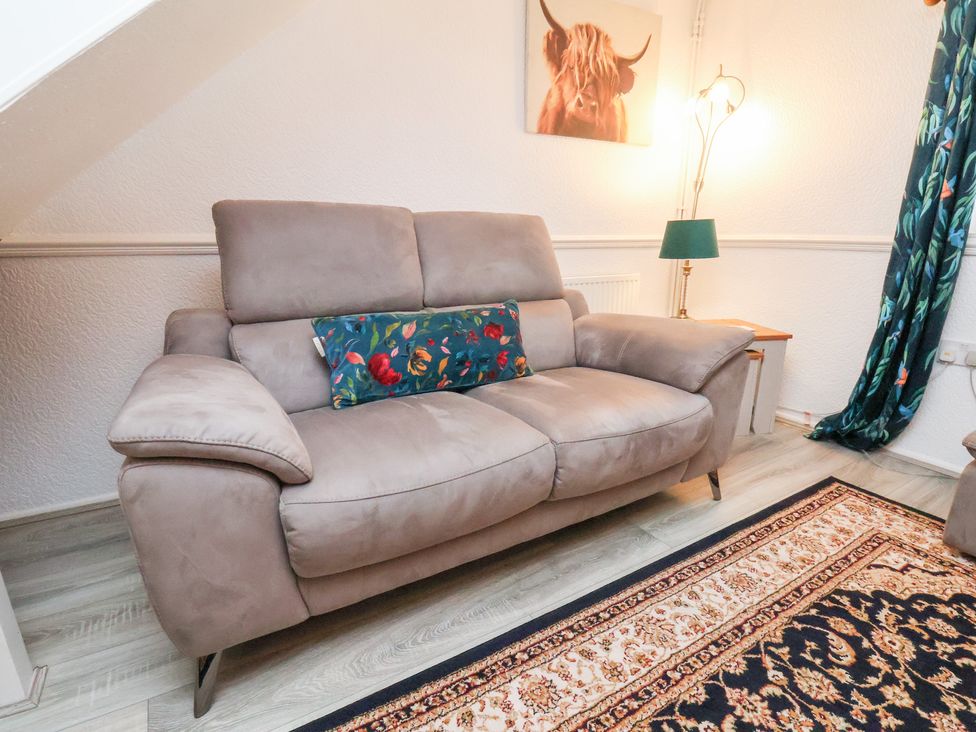 A living room with a sofa and lamp at Wayside Farm Dairy Cottage Cloughton near Burniston