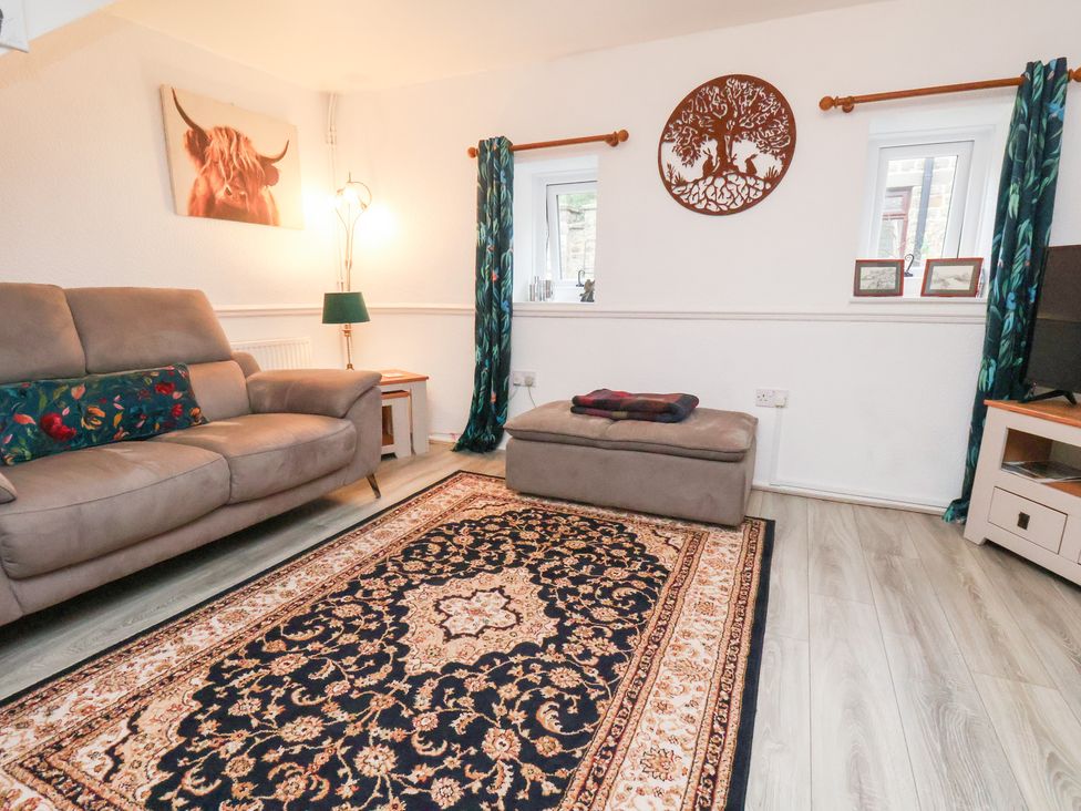 A living room with a sofa and ottoman at Wayside Farm Dairy Cottage Cloughton near Burniston