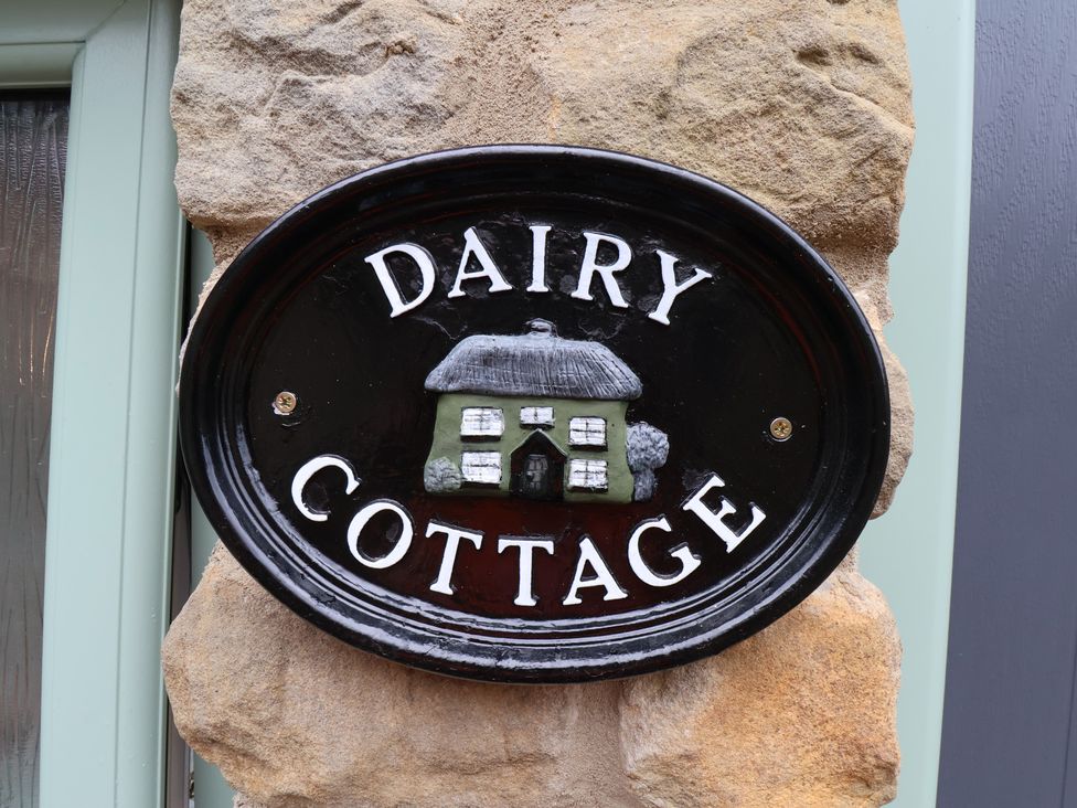 A Dairy Cottage sign on a stone wall at Wayside Farm Dairy Cottage Cloughton near Burniston