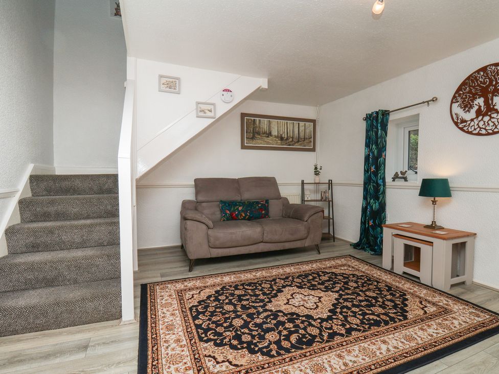 A living room with a sofa and a rug at Wayside Farm Dairy Cottage in Cloughton near Burniston