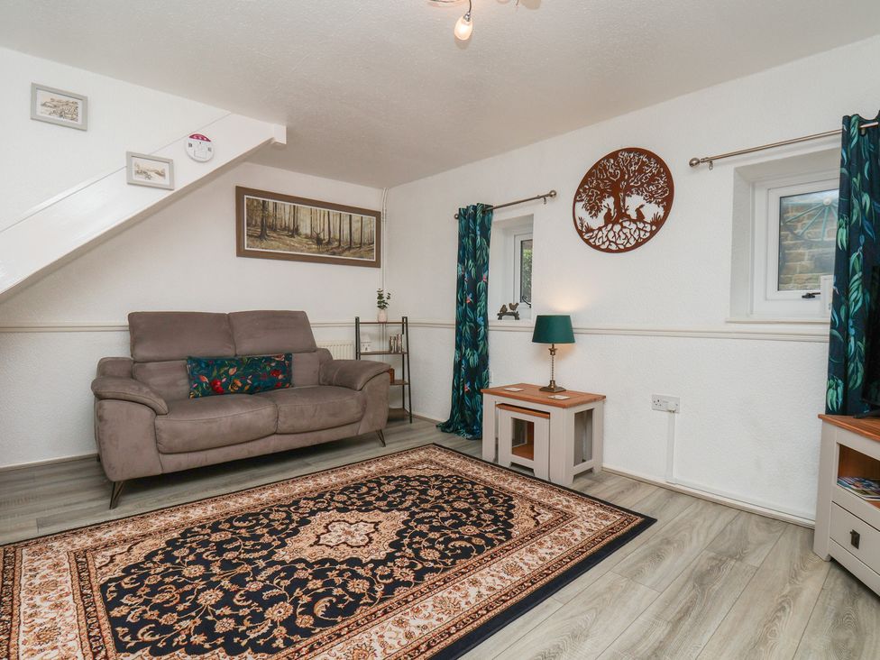 A living room with a sofa and rug at Wayside Farm Dairy Cottage Cloughton near Burniston