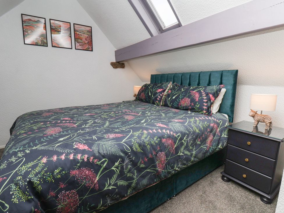 A bedroom with a bed and nightstand at Wayside Farm Dairy Cottage Cloughton near Burniston
