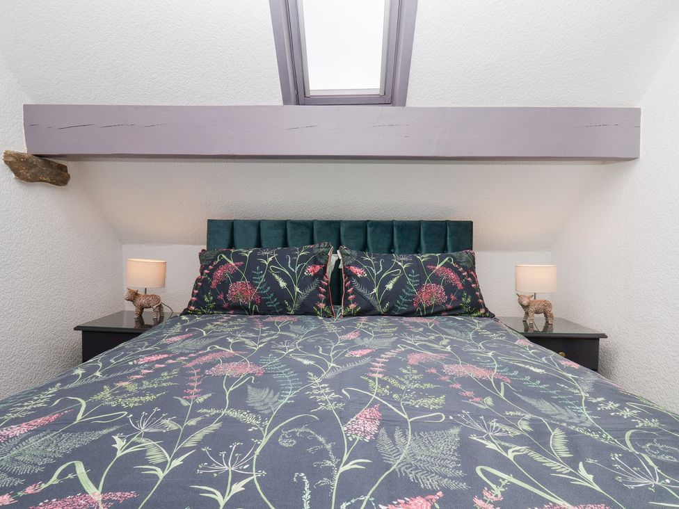 A bedroom with a bed and bedside lamps at Wayside Farm Dairy Cottage in Cloughton near Burniston