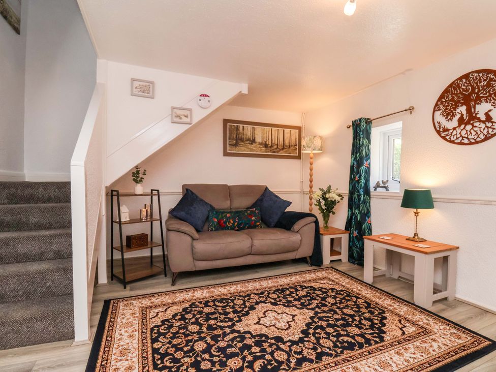 A living room with a sofa and lamp at Wayside Farm Dairy Cottage in Cloughton near Burniston