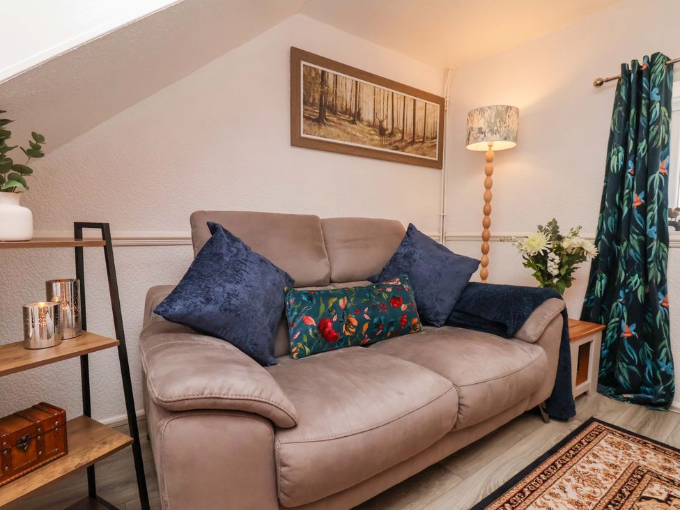 A living room with a sofa and lamp at Wayside Farm Dairy Cottage in Cloughton near Burniston