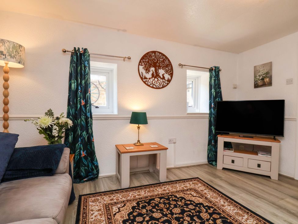A living room with a sofa and TV at Wayside Farm Dairy Cottage Cloughton near Burniston