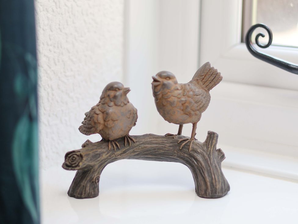 A decorative figurine of two birds on a branch at Wayside Farm Dairy Cottage Cloughton near Burniston