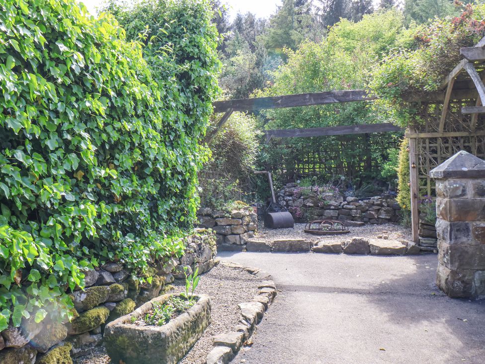 A garden area with stone walls and gravel pathways at Wayside Farm Stable Cottage in Cloughton near Burniston
