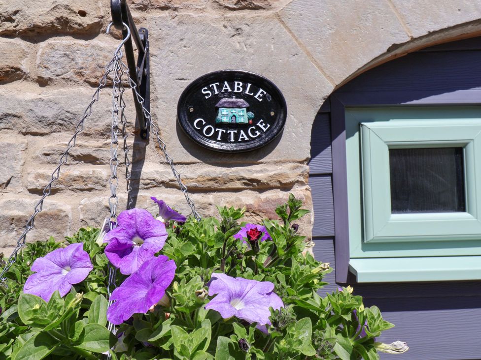 A sign reading Stable Cottage with flowers at Wayside Farm Stable Cottage Cloughton near Burniston