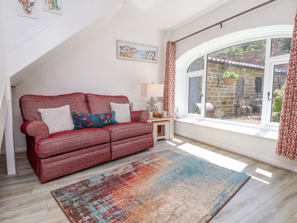 A living room with a sofa and a table at Wayside Farm Stable Cottage Cloughton near Burniston