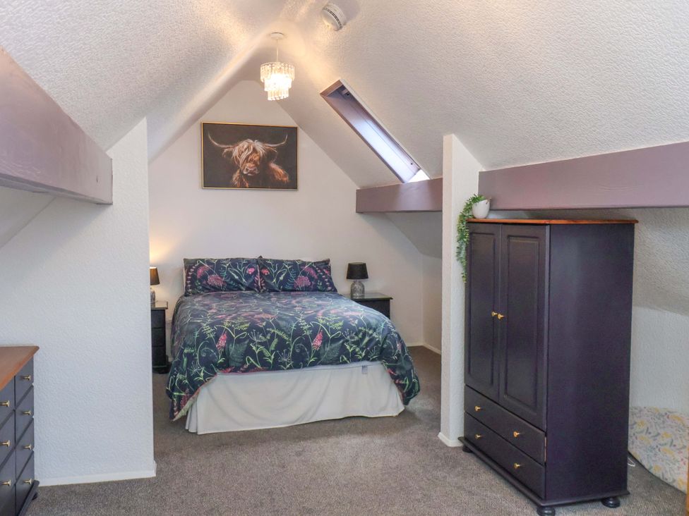 A bedroom with a bed and wardrobe at Wayside Farm Stable Cottage Cloughton near Burniston