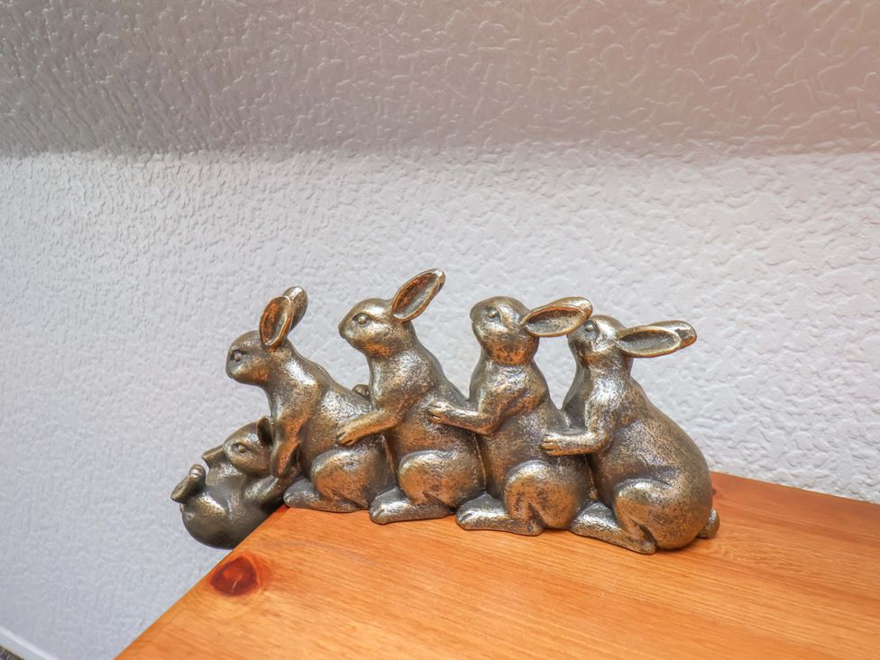A decorative item featuring rabbits on a wooden surface at Wayside Farm Stable Cottage in Cloughton near Burniston