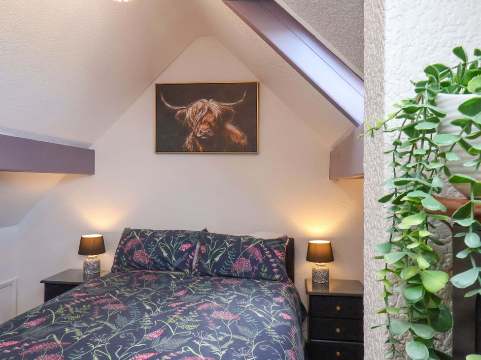 A bedroom with a bed and nightstands at Wayside Farm Stable Cottage Cloughton near Burniston