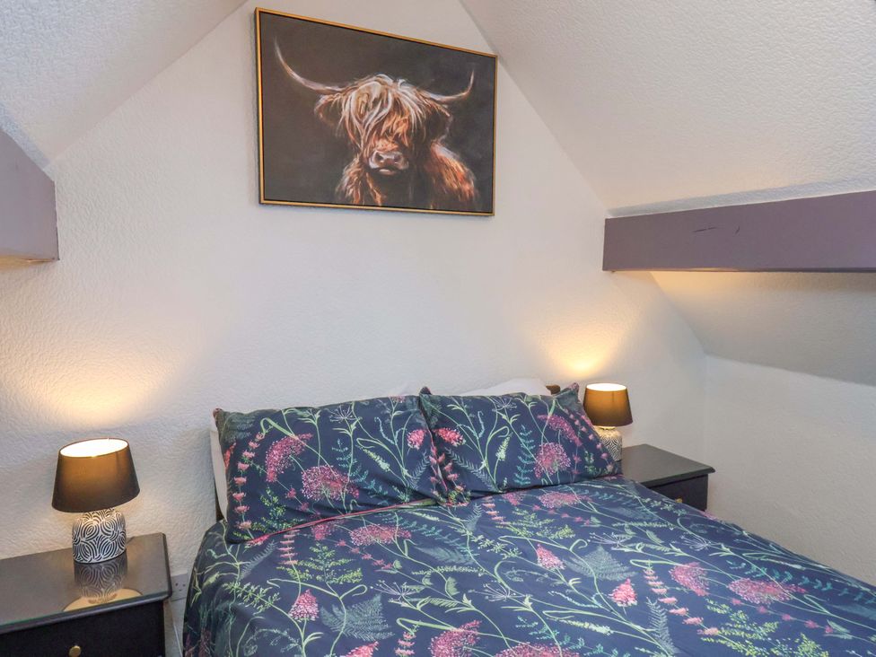 A bedroom with a bed and lamps at Wayside Farm Stable Cottage in Cloughton near Burniston