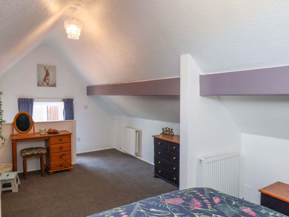 A bedroom with a dressing table and chest of drawers at Wayside Farm Stable Cottage in Cloughton near Burniston