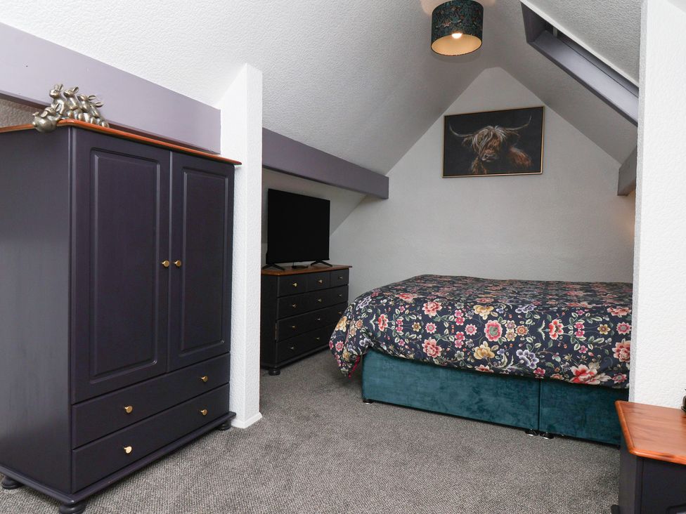 A bedroom with a bed, wardrobe, and dresser at Wayside Farm Stable Cottage Cloughton near Burniston