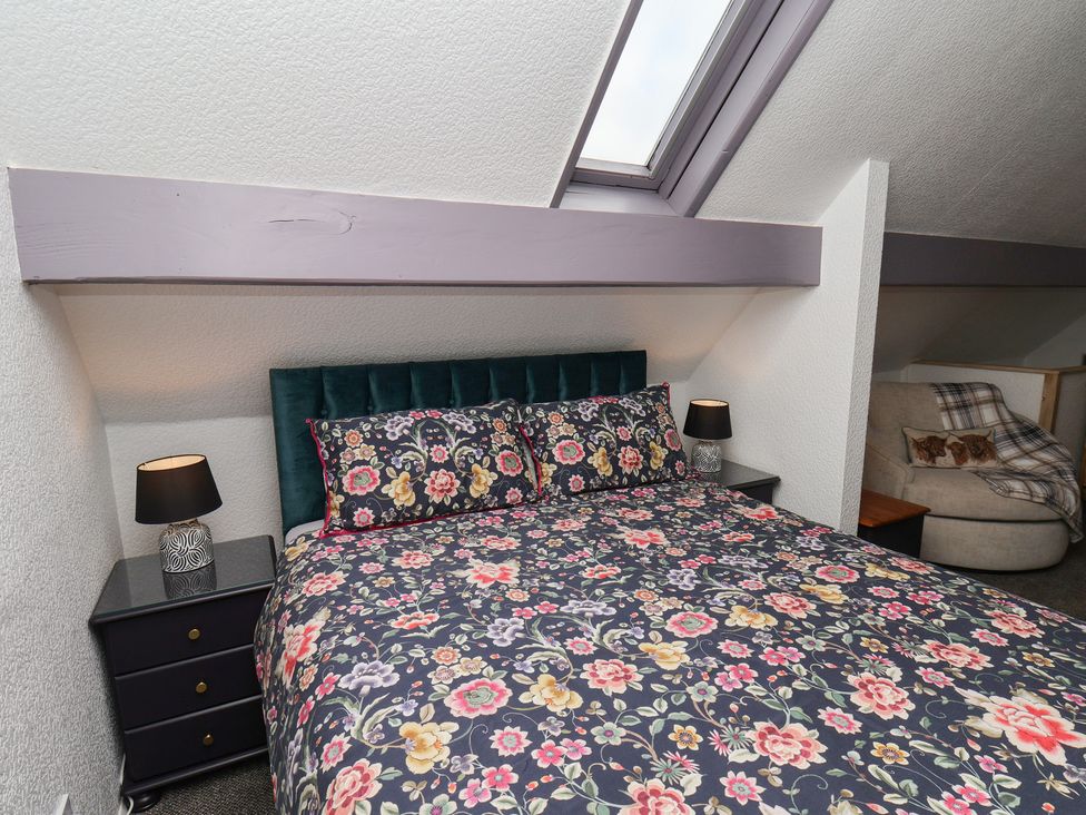 A bedroom with a bed and side table at Wayside Farm Stable Cottage in Cloughton near Burniston