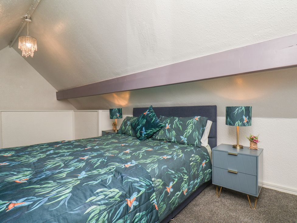 A bedroom with a bed and bedside table at Wayside Farm Cart Cottage in Cloughton near Burniston