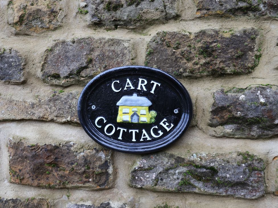 A sign reading 'CART COTTAGE' on a stone wall at Wayside Farm Cart Cottage Cloughton near Burniston