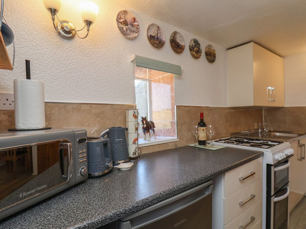 A kitchen with appliances and a window at Wayside Farm Cart Cottage Cloughton near Burniston