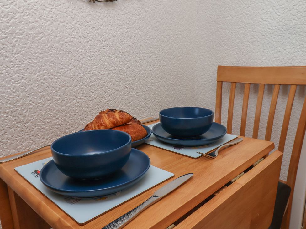 A dining table set with bowls and croissant at Wayside Farm Cart Cottage Cloughton near Burniston
