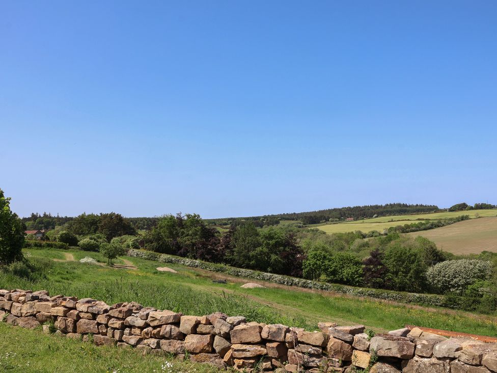 A landscape view with a stone wall and fields at Wayside Farm Cart Cottage Cloughton near Burniston