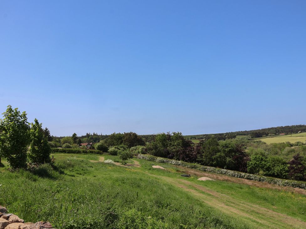 A landscape view with trees and open fields at Wayside Farm Cart Cottage Cloughton near Burniston
