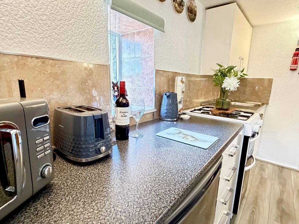 A kitchen with a toaster and kettle on the work surface at Wayside Farm Cart Cottage in Cloughton near Burniston