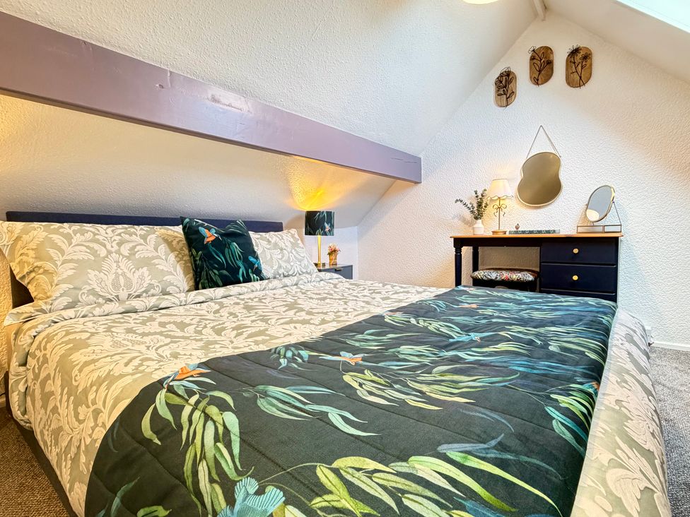 A bedroom with a bed and side table at Wayside Farm Cart Cottage Cloughton near Burniston