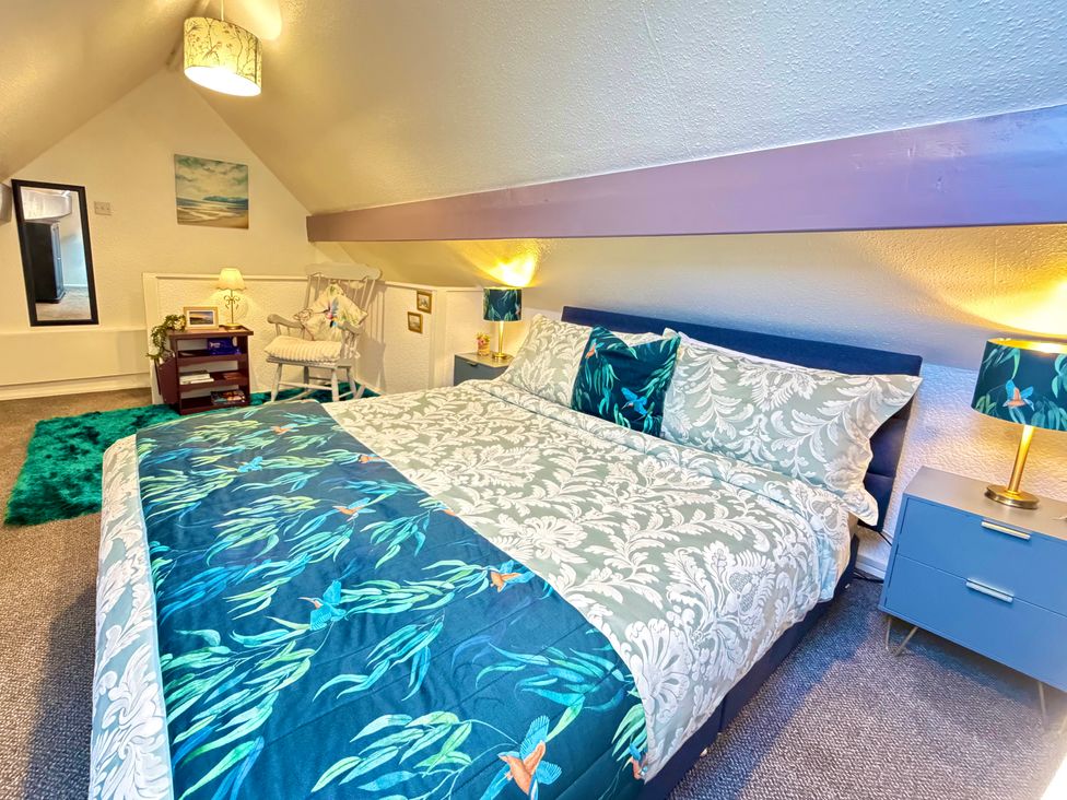 A bedroom with a bed and bedside tables at Wayside Farm Cart Cottage Cloughton near Burniston