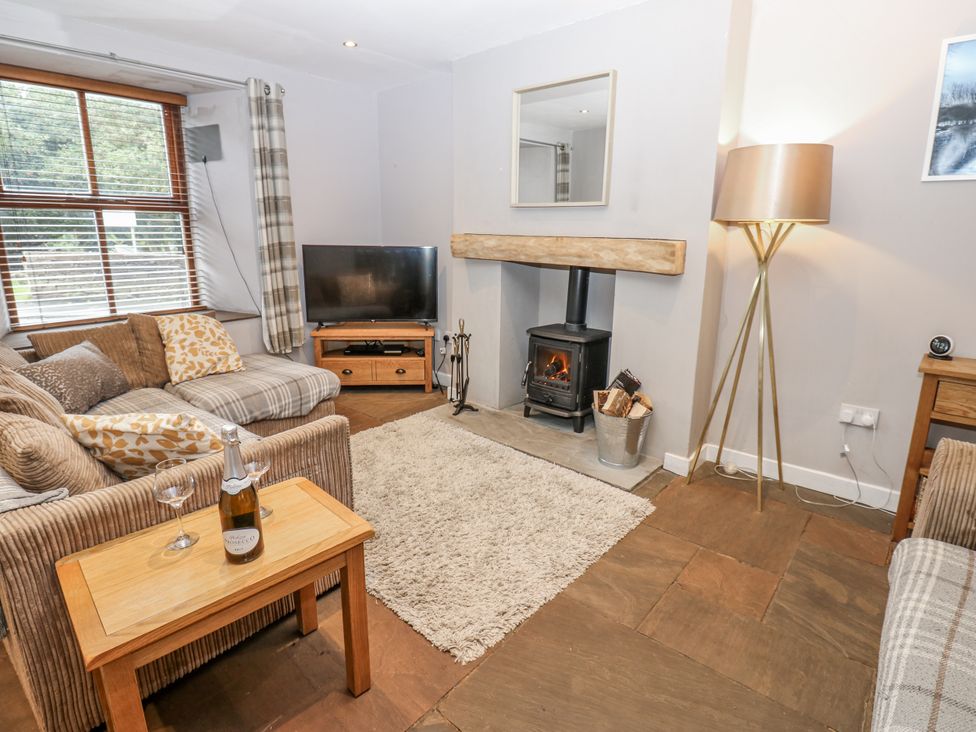 A living room with a sofa and television at Mill Race House in Alston
