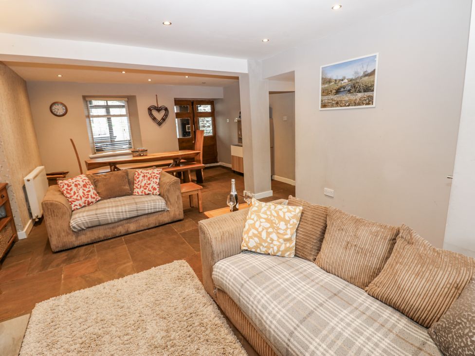 A living room with a sofa, table, and chairs at Mill Race House in Alston