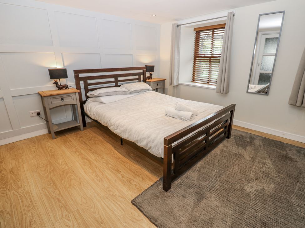 A bedroom with a bed and nightstands at Mill Race House, Alston