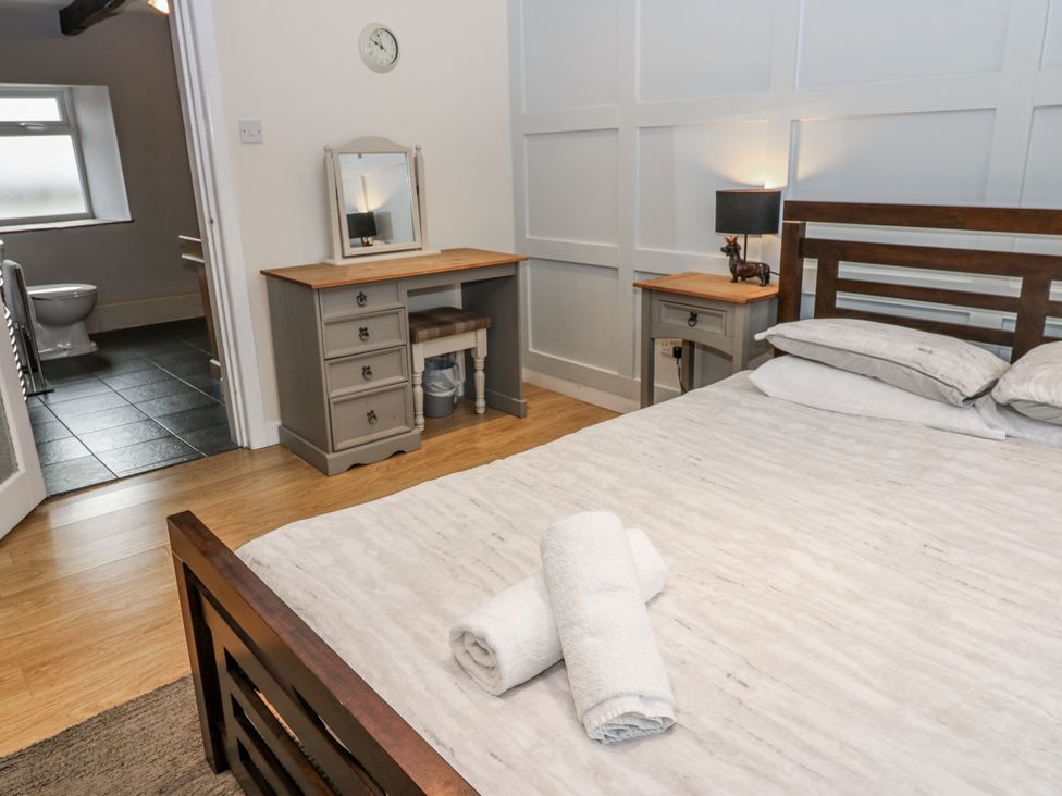 A bedroom with a bed and dressing table at Mill Race House in Alston