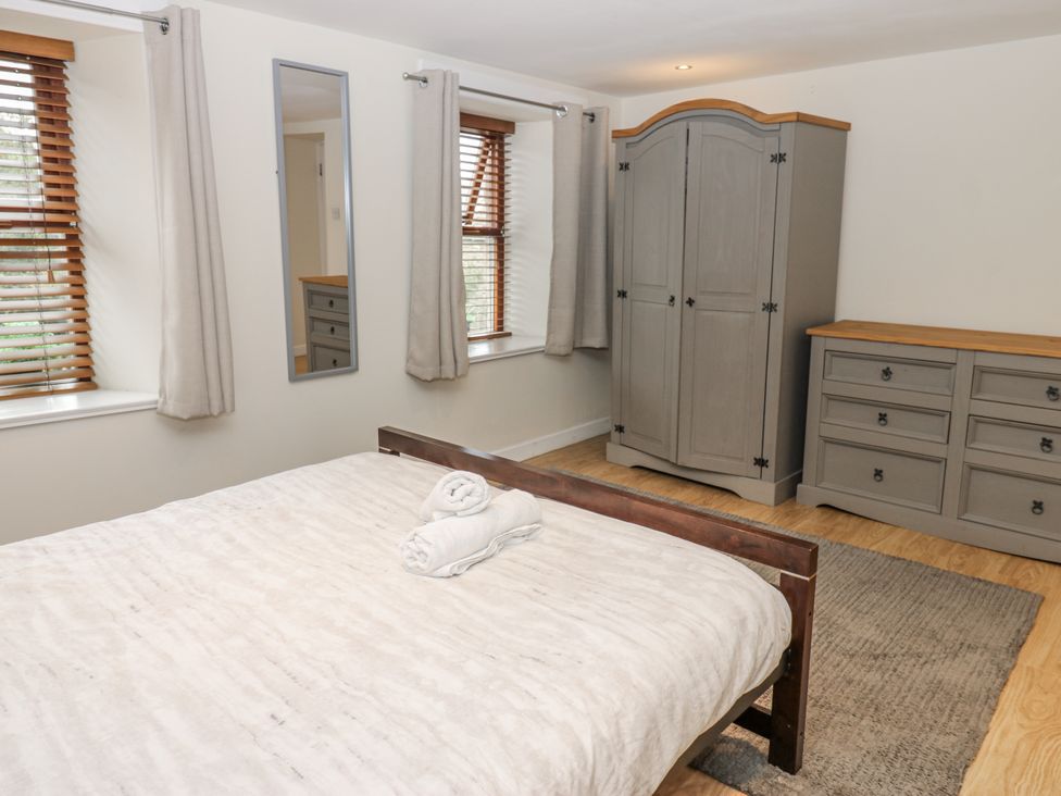 A bedroom with a bed, wardrobe and dresser at Mill Race House Alston