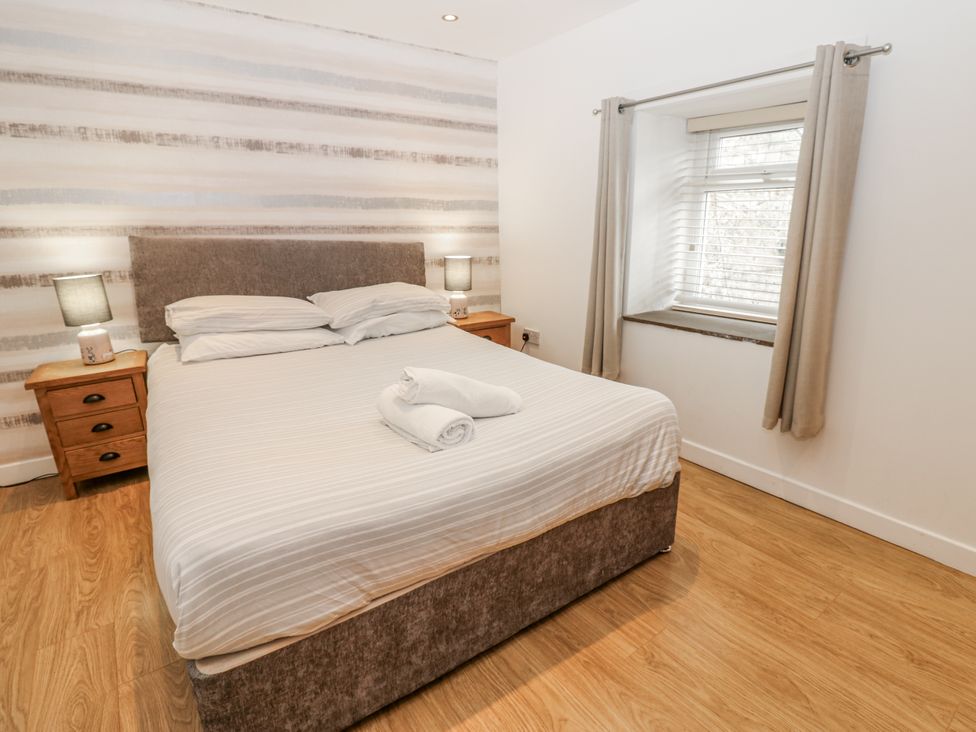 A bedroom with a bed and nightstands at Mill Race House in Alston